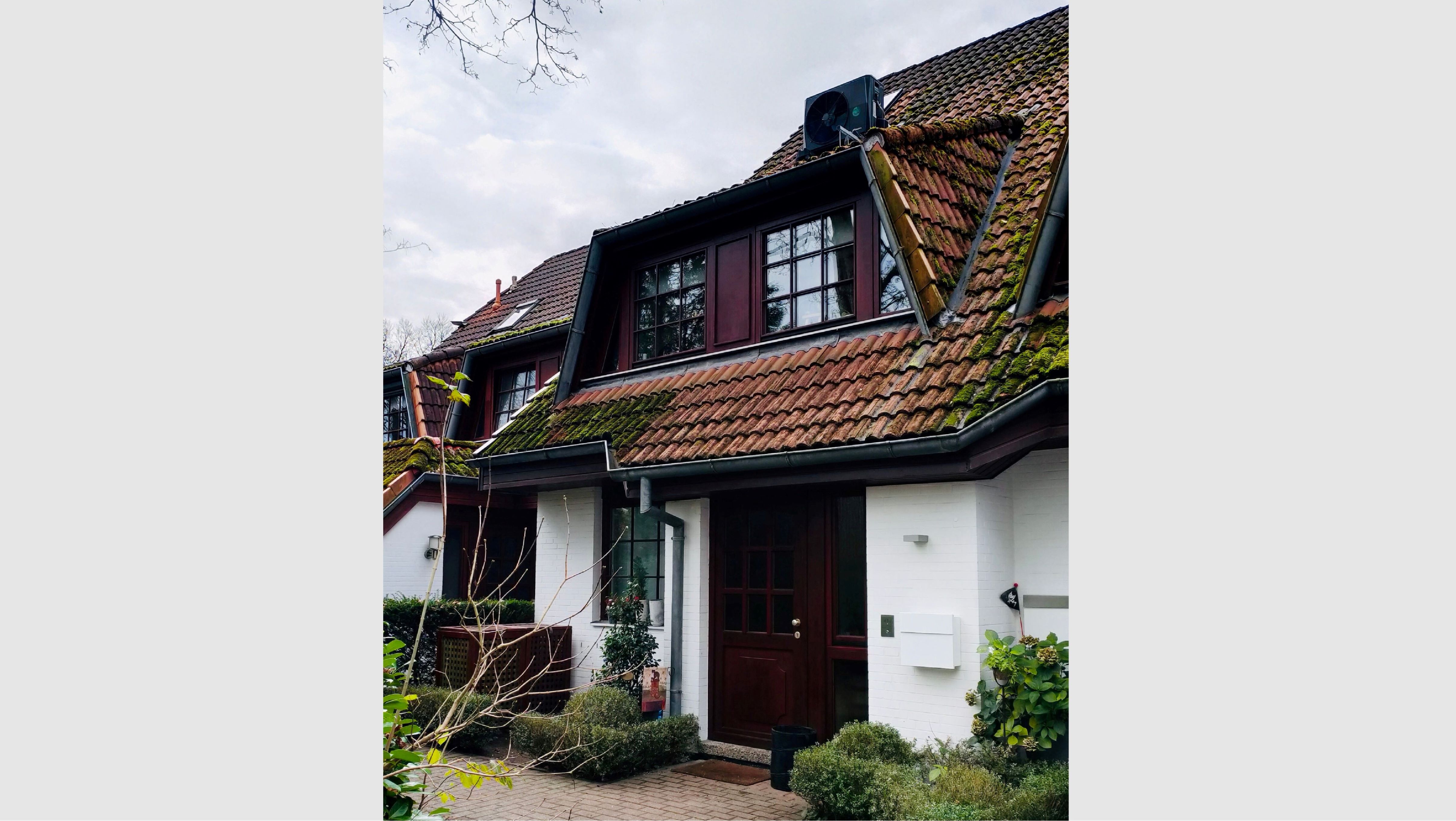 Ein Reihenhaus mit Wärmepumpe auf dem Dach.