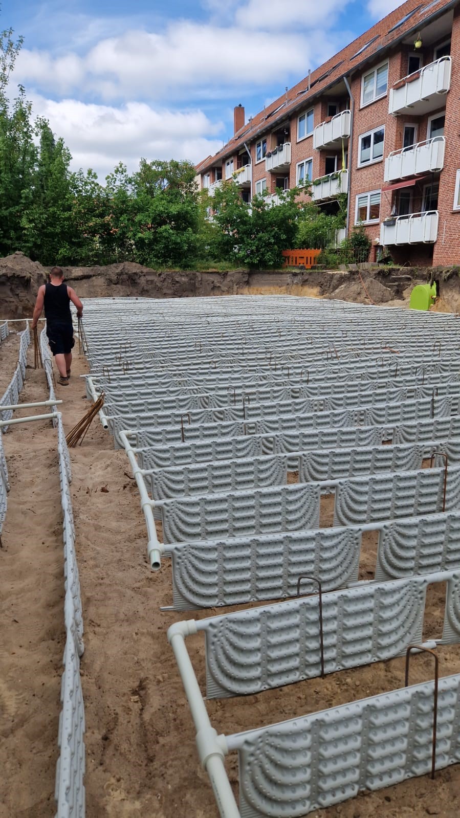 Baugrube mit schräg verlaufendem Erdkollektorfeld, Ansicht von der Seite