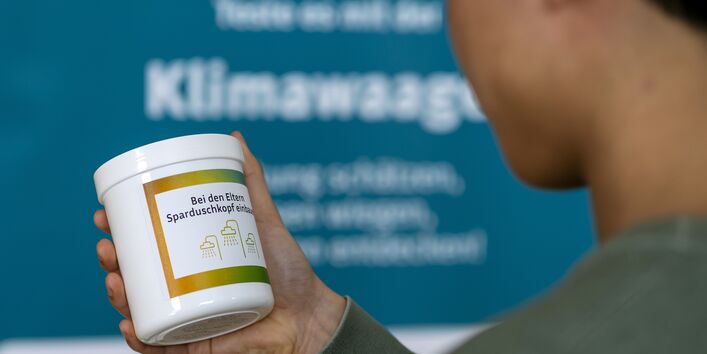 Eine Dose der Klimawaage thematisiert die Auswirkung der Entschiedung für einen Sparduschkopf für das Klima. 