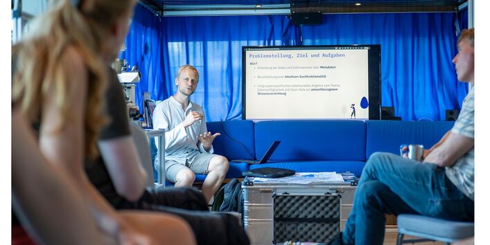 Drei Personen vor einem Bildschirm in der Kajüte der MS Halle