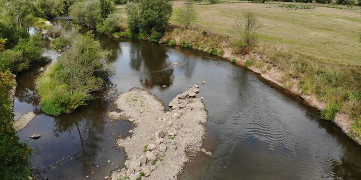 Aerial view of the Fulda. A number of large stones were installed diagonally into the riverbed. Erosion has started at the opposite riverbank.