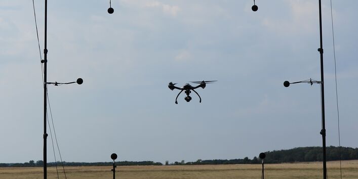Ringförmig angeordnete Mikrofone in deren Mitte eine Drohne schwebt