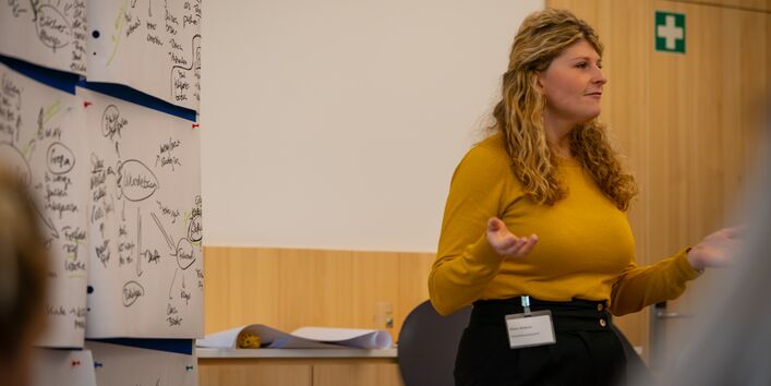 Alena Büttner vom UBA steht vor einer Pinnwand, die Diskussionsbeiträge zusammenfasst