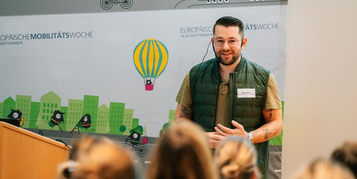 Michael Wiens steht vor der Teilnehmenden und präsentiert. 