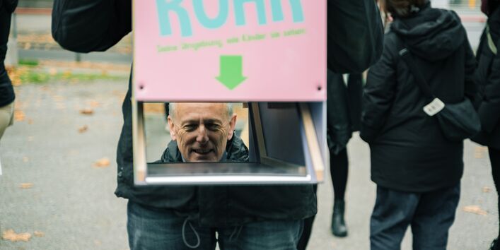 Spiegelung einer Person, die durch das umgedrehte Persikop sieht.