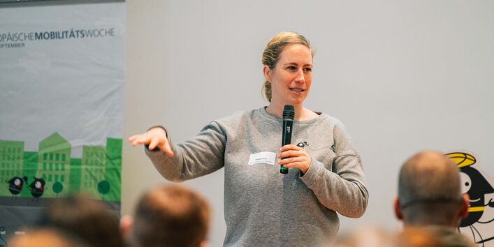 Nationale Koordinatorin Claudia Kiso stellt EMW 2024 vor und hält ein Mikrofon