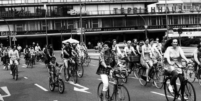 Straße ohne Autos und mit vielen Fahrradfahrern (Frauen, Männer und Kinder)