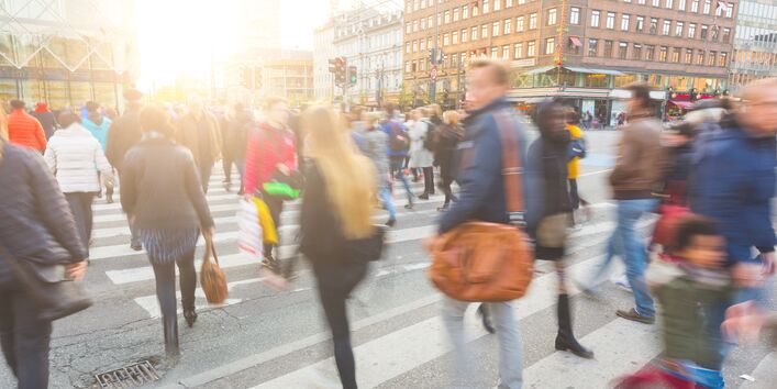 viele Menschen in der Stadt gehen über einen Zebrastreifen