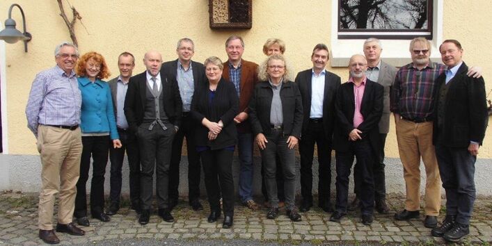Gruppenfoto mit 10 Männern und 4 Frauen vor einem Gebäude