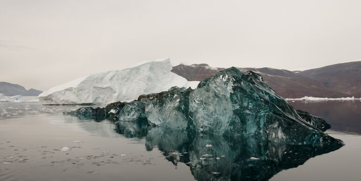 schwarz gefärbter Eisberg im Wasser 