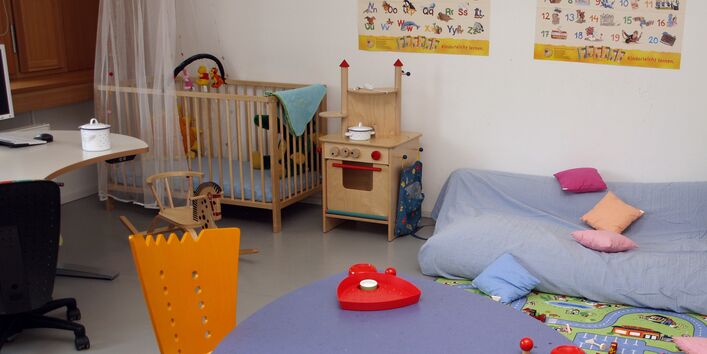 Eltern-Kind-Arbeitszimmer mit einem Schreibtisch, einer Sitzecke und einer Matratze, Spielzeug