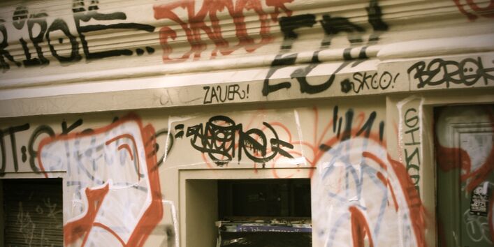 Ein Mann spielt aus dem Fenster seiner Wohnung heraus Trompete, auf dem Bürgersteig darunter schaut ein kleiner Junge mit seinem Fahrrad hoch zu dem Mann im ersten Stock und hört ihm zu.