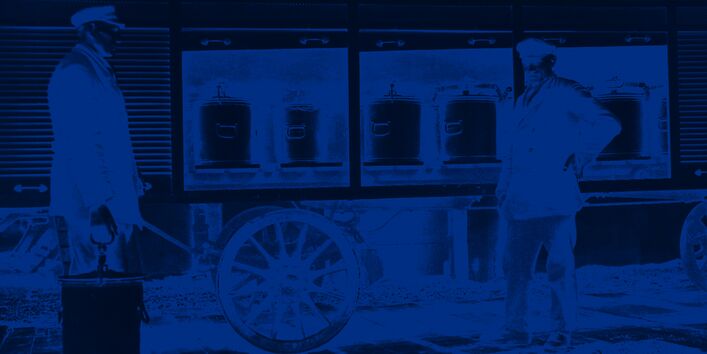 Zwei Arbeiter laden Eimer auf einen Wagen mit Rolläden