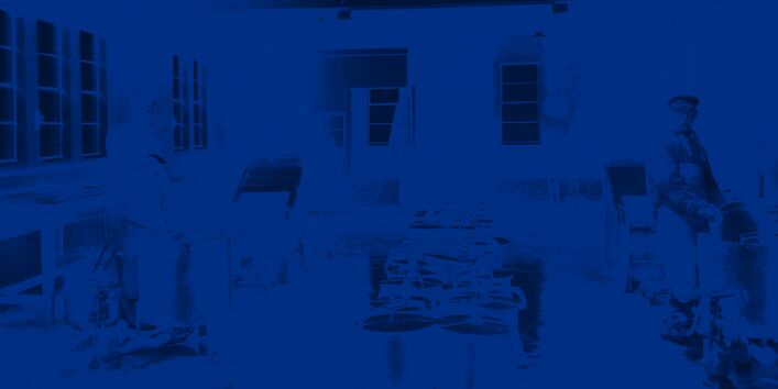 Entleerung und Wäsche der Wechselkübel durch zwei Arbeiter in einer Waschküche