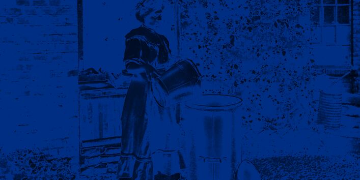 Eine Frau entsorgt müll aus einem kleinen Hauseimer in einen hohen Standeimer.