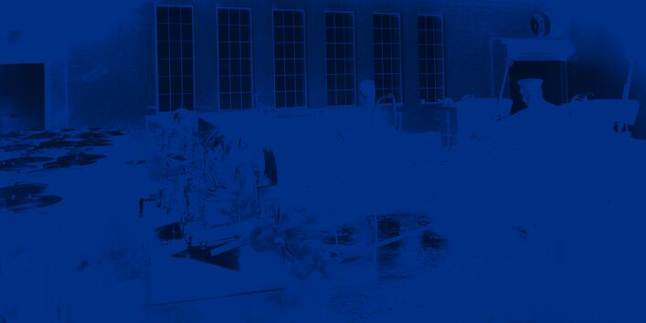 Bürstenwaschmaschine in einem Fabrikgebäude, ein Arbeiter zieht eine Tonne aus der Maschine