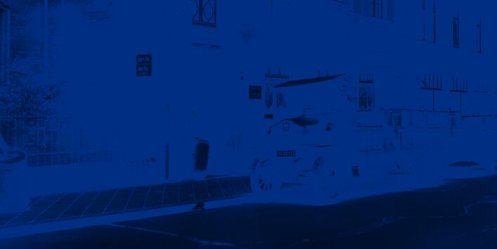 Tonnen werden vor einem Gebäude von einem Laster abgeholt.