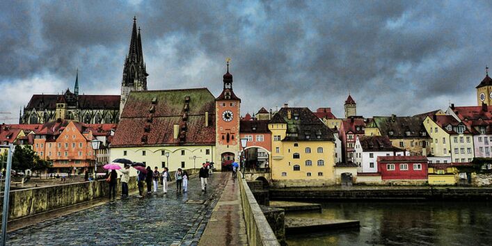 Blick auf Regensburg im Regen von einer Brücke.