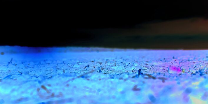 The picture shows a barren arable field enveloped in warm light emanating from a low sun. 