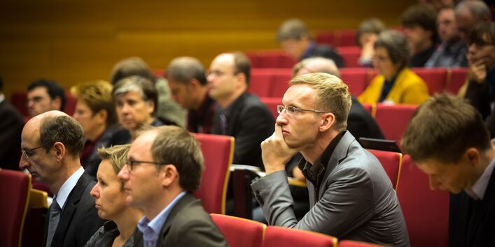 Teilnehmer sitzen im Hörsaal