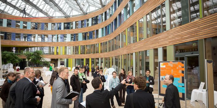 Teilnehmer stehen im Forum des Umweltbundesamtes an einer Präsentationsinsel