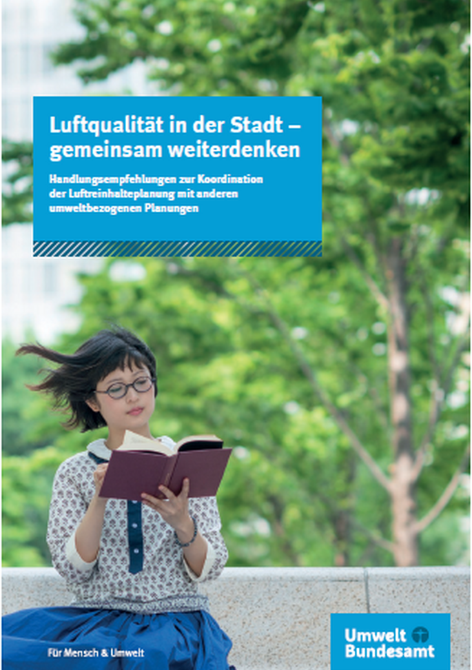 Eine Frau sitzt im Grünen und liest ein Buch