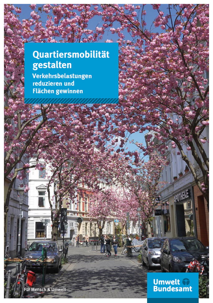 ruhige Anwohnerstraße mit blühenden Zierkirschen, Fußgängern und abgestellten Fahrrädern