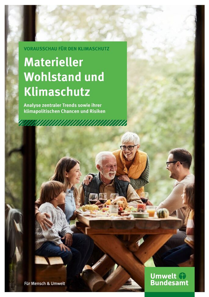 Menschen sitzen um einen gedeckten Tisch im Freien