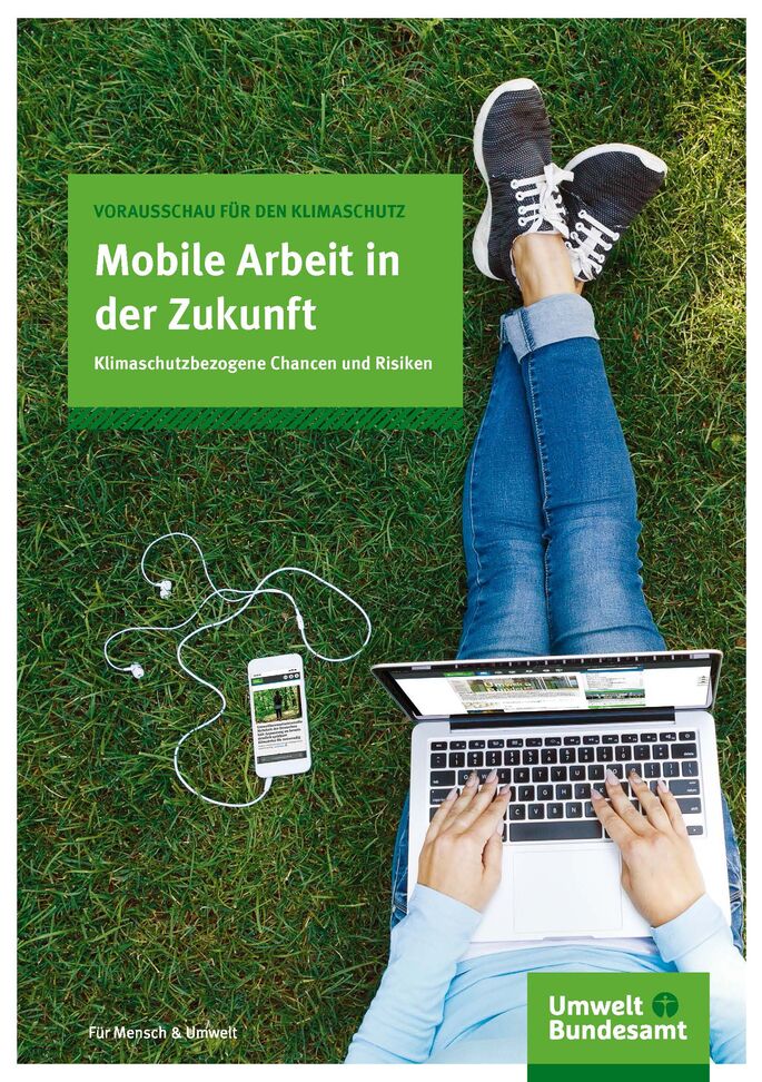 Mensch sitzt mit Notebook auf der Wiese