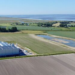 Ansicht der Produktionsstätte von oben, dahinter die Abwasseranlage und die Lagune.