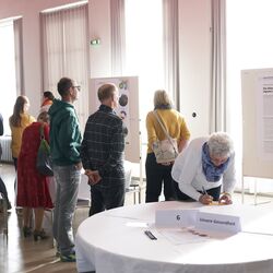 Mehrere Menschen stehen vor Schautafeln, die die Folgen der Klimakrise für die Gesundheit aufzeigen.