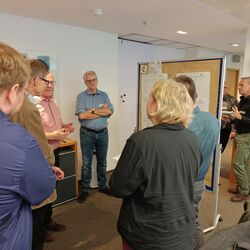 A group of people standing in a circle having a discussion