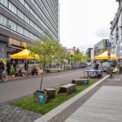 Randstreifen einer Straße ist von Sitzgruppen belegt