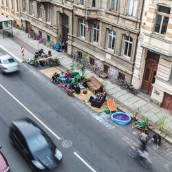 Gruppe von Menschen hat sich auf Seitenparkstreifen eine kleine Lounge eingerichtet