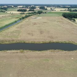 Luftbild der Hase und umgebenden Überflutungsräumen. Ein Stillgewässer reicht weit in eine Grünlandfläche hinein.
