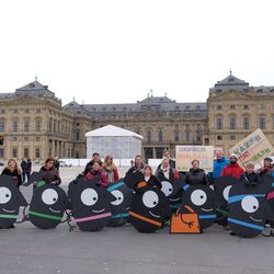 Teilnehmende stehen hinter den Maskottchen, die sie getragen haben.