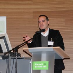 Dr. Alexander Ferstl von der Europäische Kommission, Generaldirektion für Klimapolitik, steht auf der Bühne hinter dem Rednerpult und hält seinen Vortrag