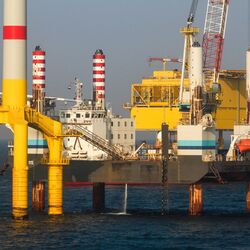 Das Foto zeigt im Vordergrund die Tripod-Gründungsstruktur und dahinter das Installationsschiff