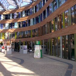 Der gepflasterte, mit Glas überdachte Eingangsbereich des UBA-Dessau-Roßlau mit Exponaten einer Ausstellung