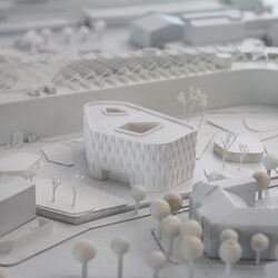 von Architekten gebautes, ganz in weiß gehaltenes Modell eines modernen vierstöckigen, polygonalen Flachbaus und seiner Umgebung