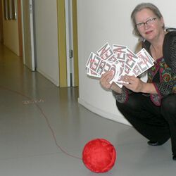 Christiane Keppler hockend mit Garnrolle & Schriftschablonen