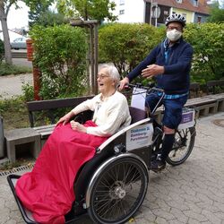 Seniorin lässt sich in Rikscha fahren