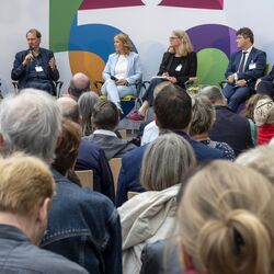 Auf Bühne sitzen die Moderatorin sowie Reiner Haseloff, Ministerpräsident des Landes Sachsen-Anhalt, Steffi Lemke, Dirk Messner, Lilian Busse sowie Robert Reck und haben Fragen des Umwelt- und Klimaschutzes aus verschiedenen Perspektiven beleuchtet.