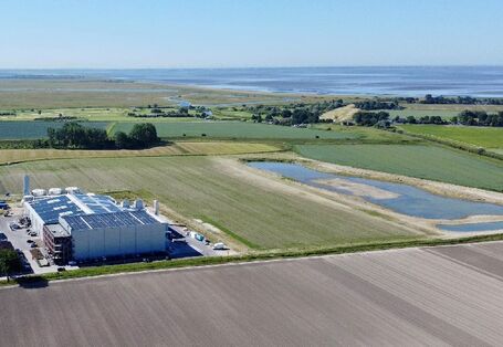 Ansicht der Produktionsstätte von oben, dahinter die Abwasseranlage und die Lagune.