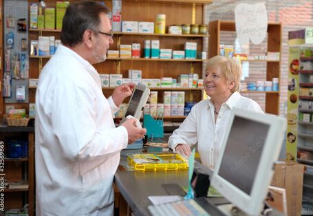 Foto von Beratungssituation am Tresen in einer Apotheke.