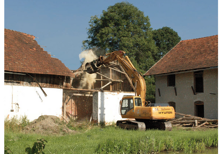 Das Cover der Broschüre: Rücknahme von Siedlungsbereichen als Anpassungsstrategie  - Ein Bagger reißt ein altes Gebäude ab.