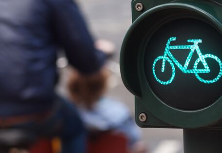 Fahrradampel steht auf Grün, Mann mit gelbem Rad ist vorbeigefahren
