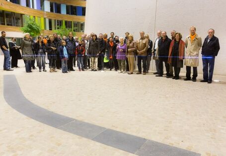 Im Atrium des UBA Dessau steht eine Gruppe von Personen. Etwa in Hüfthöhe zeigt ein blauer Laser den Stand des Wasserpegels.