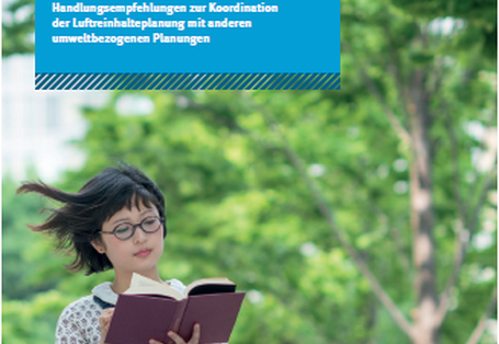 Eine Frau sitzt im Grünen und liest ein Buch