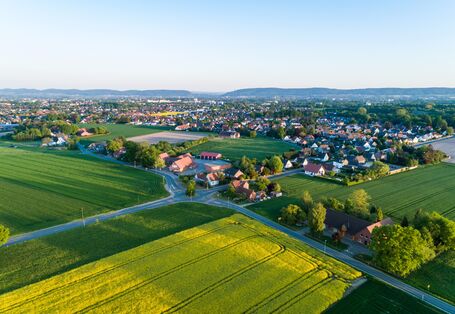 Luftbild einer ländlichen Siedlung zwischen Feldern.